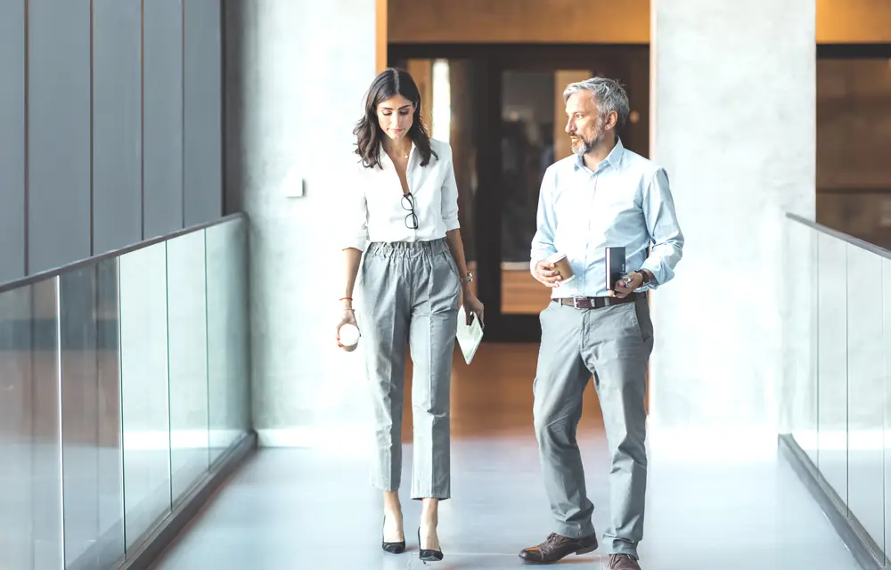 Two colleagues discuss in the corridor in the office building